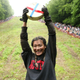 The winner of this year’s Cooper’s Hill Cheese-Rolling competition displays her prize.